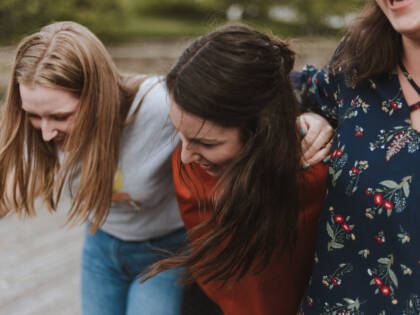 Three women walking and laughing.