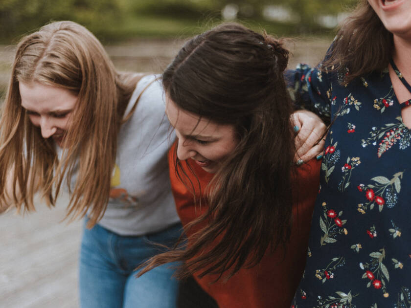 Three women walking and laughing.
